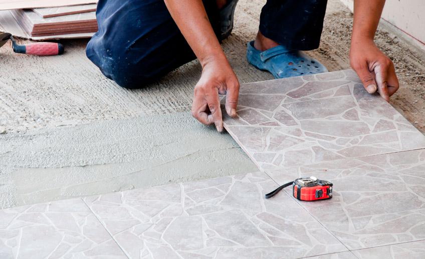 Floor tiles being laid and measured